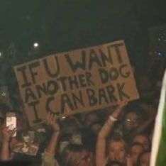 a group of people holding up signs at a concert