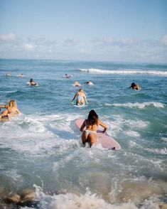 several people in the ocean with surfboards