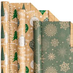 christmas wrapping paper with snowflakes and evergreen trees on them in gold, green, and white