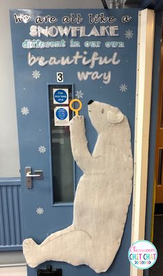 a white polar bear sitting on top of a blue door with snowflake written on it