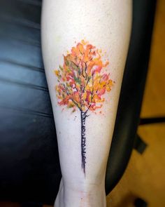 a woman's leg with a colorful tree tattoo on her left calf and the words, i love you in cursive writing