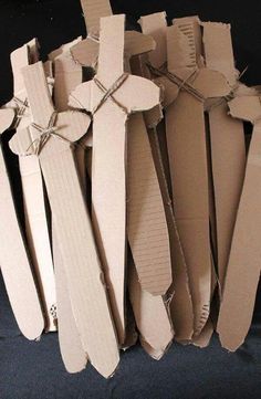 several pieces of cardboard are stacked on top of each other in order to be made into crosses