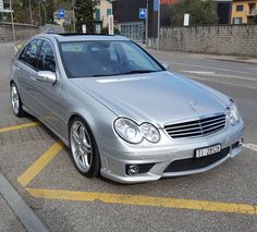 a silver car is parked on the side of the road