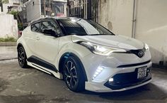 a white and blue car parked in front of a building