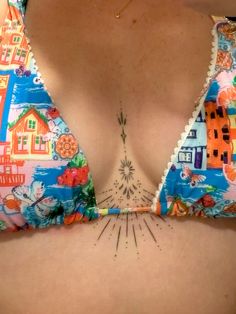 a close up of a woman's bra with tattoos on her chest and back