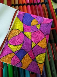 an image of colorful art on display with crayon pencils in the background