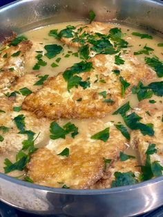 a pan filled with meat covered in gravy and garnished with parsley