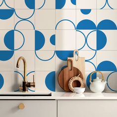 a kitchen with blue and white tiles on the wall next to a wooden cutting board