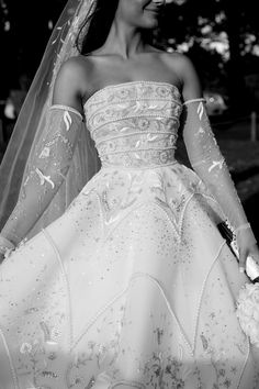 a woman in a wedding dress walking down the street