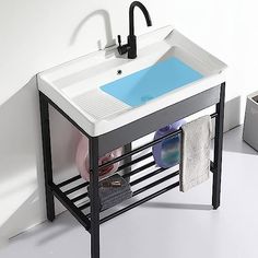 a white sink sitting under a faucet next to a towel rack