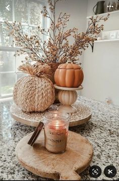 some pumpkins are sitting on top of a table with candles and other things around them