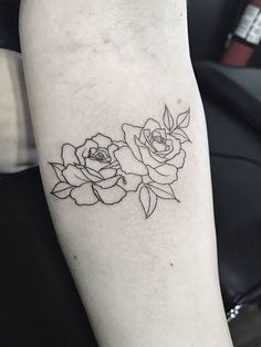 a black and white photo of two roses on the arm