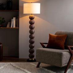 a living room with a chair, lamp and bookshelf