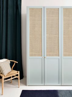 a white cabinet sitting next to a chair in a room