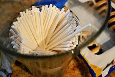 a cup filled with white matches sitting on top of a table