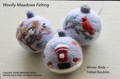 three needled ornaments are sitting on a white tablecloth with the words woolly meadows felting written below them