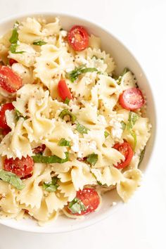 a white bowl filled with pasta and tomatoes