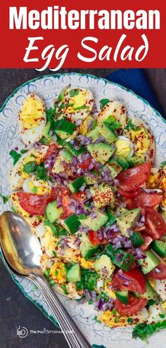 an egg salad with tomatoes, cucumber and other vegetables on a white plate