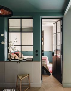 an open door leading to a bedroom with blue walls and white cabinets, along with a wooden stool