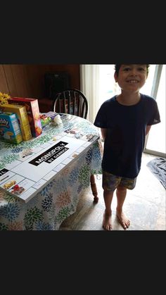 a young boy standing in front of a table