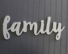 the word family written in white letters on a gray wall