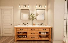 a bathroom with double sinks and two mirrors on the wall next to eachother