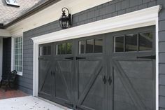 a gray garage with two doors and windows