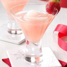 two martinis with ice and strawberries in them