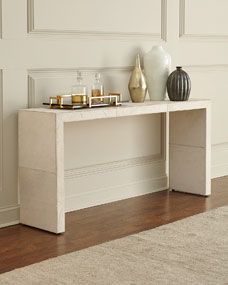 a console table with candles and vases on it