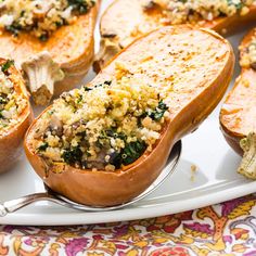 baked stuffed sweet potatoes with spinach, cheese and other toppings on a white platter