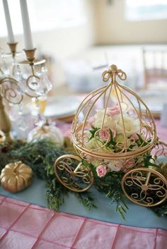 a table topped with a birdcage filled with flowers