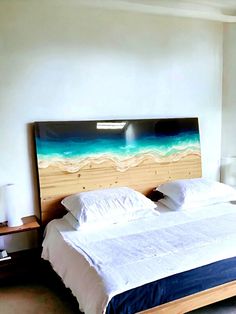 a large bed sitting in a bedroom next to a wall mounted painting on it's side