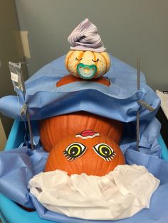 a pumpkin sitting on top of a blue chair with an odd face painted on it