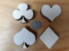 four pieces of wood cut out to look like hearts, spades and a penny