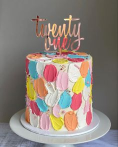 a multicolored cake with the words twenty fives on top and hearts painted all over it