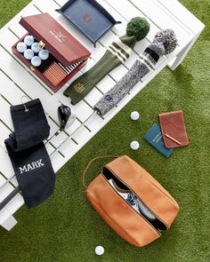 the contents of a purse are laid out on the ground next to golf balls and other accessories