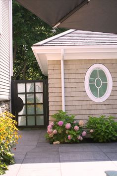 a house with flowers in front of it and an open umbrella over the entrance door