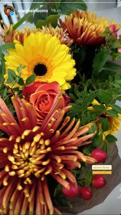 a vase filled with lots of different colored flowers