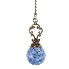 a blue glass ball is hanging from a chain on a white background with an ornate design