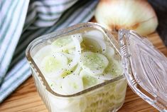 sliced onions in a glass container on a cutting board