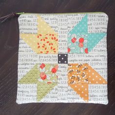 the zippered pouch is decorated with colorful patchwork and polka dot designs on it