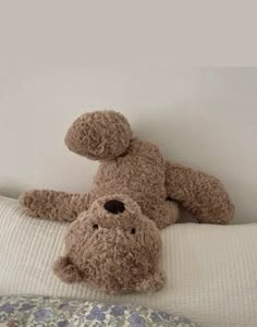 a teddy bear laying on top of a bed