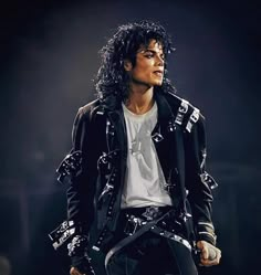 michael jackson performing on stage with his hands in his pockets and wearing black leather pants