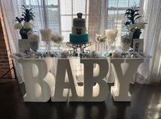 a baby shower table with cake and decorations