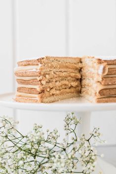 there is a cake that has been cut in half on a plate with some flowers