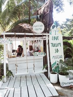 a woman sitting at a table in front of a sign that says live tulum & matcha