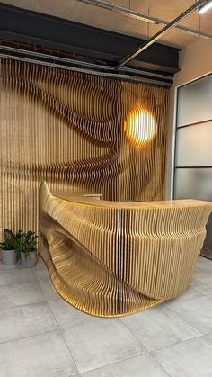 a large wooden bench sitting in front of a wall with an artistic design on it