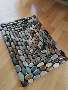 a rug made out of rocks on the floor in a room with hardwood floors and hard wood flooring