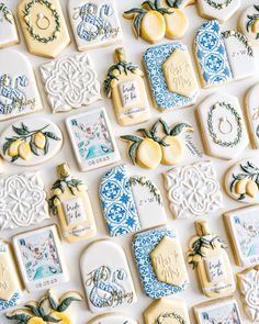 many decorated cookies are arranged in rows on a white surface with blue and yellow accents