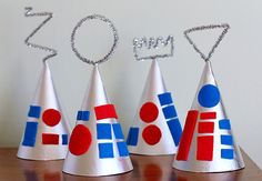 three party hats with the word zoom spelled out in front of them on a table